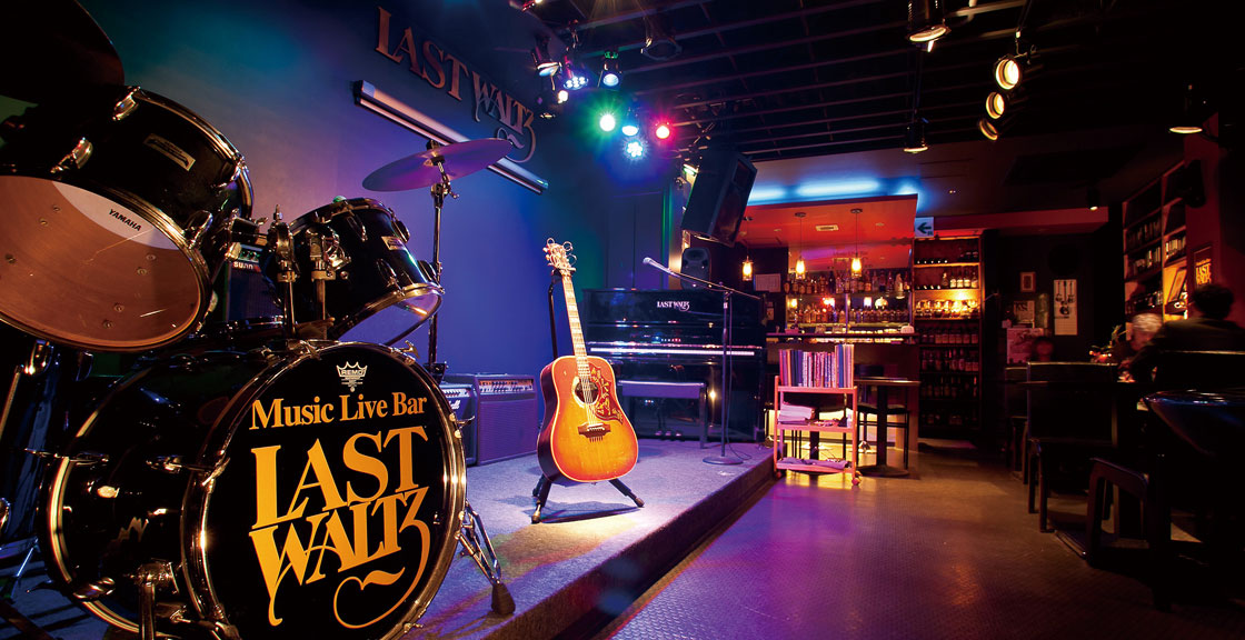 ドラムセットとギターの置かれた店内ステージ